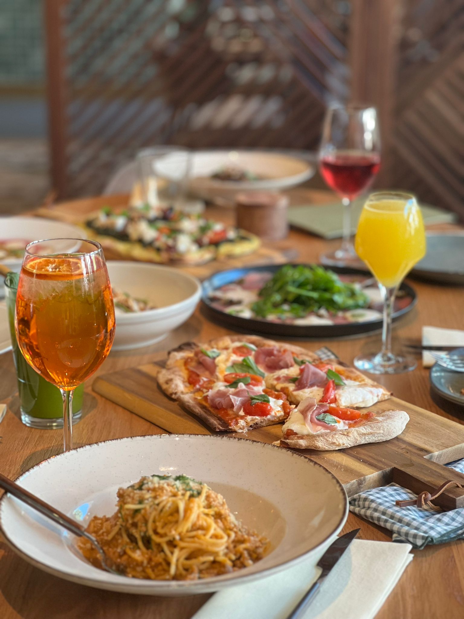 Mesa com pizza, pasta e cocktails na Casica Trattoria